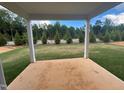 Covered patio overlooks a beautifully landscaped lawn and lush greenery at 766 Old Station Pointe, Angier, NC 27501