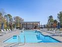 Community pool featuring a covered lounge area and ample seating for residents to enjoy a relaxing day at 766 Old Station Pointe, Angier, NC 27501