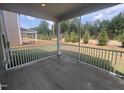 Relaxing screened porch featuring white railings and views of the landscaped backyard and sprinkler system at 766 Old Station Pointe, Angier, NC 27501