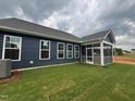Inviting screened-in porch extending from the home, surrounded by a newly laid lawn and dark blue siding at 771 Old Station Pointe, Angier, NC 27501