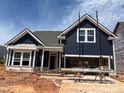 A charming, newly-built two-story home featuring a dark blue exterior with white trim and an attached two-car garage at 771 Old Station Pointe, Angier, NC 27501
