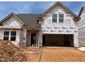 New construction home with gray roof and white building wrap, awaiting finishing touches at 771 Old Station Pointe, Angier, NC 27501