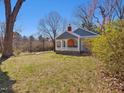 Cozy blue cottage featuring a welcoming covered porch, set on a large, grassy lot at 774 Cornelius St, Hillsborough, NC 27278
