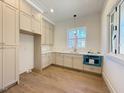 Well-lit kitchen with custom cabinets, quartz countertops, stainless steel fixtures, and hardwood floors at 7808 Ailesbury Rd, Wake Forest, NC 27587