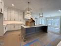 Spacious kitchen with white cabinets, a large island, and modern pendant lighting fixtures at 7808 Ailesbury Rd, Wake Forest, NC 27587