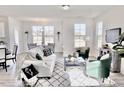 Open-concept living room and dining area with large windows, stylish furnishings, and contemporary decor at 1007 Shovelhead Dr # 4, Durham, NC 27703