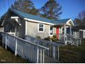 Accessible one-story home featuring a blue metal roof and a ramp leading to the covered porch at 912 Martin Luther King Jr Dr, Smithfield, NC 27577