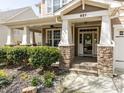 Inviting front porch with stone accents, white pillars, and a welcoming entrance to the home at 921 Marshall Farm St, Wake Forest, NC 27587