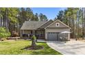 Charming single-story home featuring a cozy front porch, a two-car garage, and beautifully landscaped front yard at 97 Silver Creek Dr, Clayton, NC 27520
