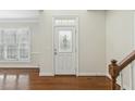 Bright foyer featuring hardwood floors, staircase, and a decorative glass white front door at 104 Low Country Ct, Morrisville, NC 27560
