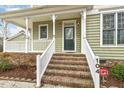 Inviting front porch with brick steps, white railings, and elegant decorative pillars and accents at 104 Low Country Ct, Morrisville, NC 27560