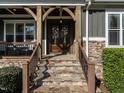 Inviting front entrance with stone steps and wood supports on a covered porch at 107 Bella Casa Way, Clayton, NC 27527