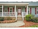 Charming front porch with brick stairs, white railing, and plants near the entrance at 108 Birdie Ct, Rocky Mount, NC 27804