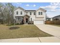 Charming two-story home with white siding, stone accents, landscaping, two-car garage, and a lovely, well-maintained lawn at 111 Kim Bark Path, Garner, NC 27529