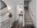 Inviting home entryway with hardwood floors, staircase, a white console table, and stylish accents at 1118 Tofino Dr, Durham, NC 27704
