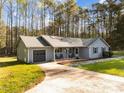 View of the home's exterior showing the driveway, garage, front porch, and beautiful landscaping at 11404 Leesville Rd, Raleigh, NC 27613