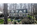 Attractive home with a covered porch and dormer windows, nestled among mature trees at 1229 Westerham Dr, Wake Forest, NC 27587