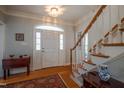 Bright foyer featuring hardwood floors, a staircase with white railings, and a charming entryway table at 1229 Westerham Dr, Wake Forest, NC 27587