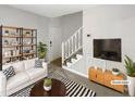 Bright, staged living room with stylish decor and staircase to upper level at 129 Bridges Ln, Youngsville, NC 27596