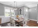 Bright dining room featuring hardwood floors, a modern light fixture, and views of the front yard at 14 E Saddle Ct, Archer Lodge, NC 27527