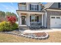 Inviting front porch with stone steps, comfortable seating, and manicured landscaping at 14 E Saddle Ct, Archer Lodge, NC 27527