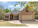 Attractive home with a well-manicured lawn, stone walkway, and two-car garage is enhanced with a warm facade and mature trees at 1409 Turner Farms Rd, Garner, NC 27529