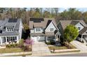 An aerial view of a gray home featuring a manicured lawn, solar panels, driveway, and lovely, mature landscaping at 142 Old Piedmont Cir, Chapel Hill, NC 27516