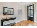 An entryway with a dark wood floor, a black console table, a black framed mirror, and a paneled front door at 142 Old Piedmont Cir, Chapel Hill, NC 27516