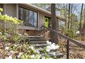 Close-up of home's entrance featuring vibrant green door, stone steps, and mature landscaping at 1516 Cumberland Rd, Chapel Hill, NC 27514