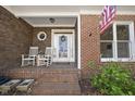 Cozy front porch with rocking chairs, brick columns, and charming details at 155 Chimney Rise Dr, Cary, NC 27511