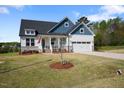 Charming two-story home features a manicured lawn, attached two-car garage, and covered front porch at 16 Blue Monarch Ln, Fuquay Varina, NC 27526