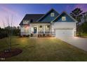 Charming two-story home with a manicured lawn, attached two-car garage, and inviting covered front porch at 16 Blue Monarch Ln, Fuquay Varina, NC 27526