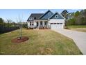 Charming two-story home with a manicured lawn, attached two-car garage, and covered front porch at 16 Blue Monarch Ln, Fuquay Varina, NC 27526