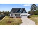 Two-story home with a manicured lawn, attached garage, welcoming front porch, and beautiful landscaping at 16 Blue Monarch Ln, Fuquay Varina, NC 27526
