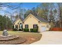 Exterior shot of the home shows the front and side, with a large yard and landscaping at 1638 Crystal Ln, Stem, NC 27581