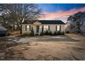 Charming one-story home with a cozy front porch and landscaped yard at sunset at 227 Coley Farm Rd, Fuquay Varina, NC 27526