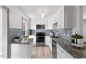 Modern kitchen featuring granite counters, white cabinets, and stainless steel appliances at 2457 Derby Dr, Raleigh, NC 27610