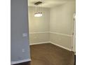 Bright dining room with modern lighting fixture, neutral walls, white trim, and wood-look laminate floors at 2631 Oldgate Dr # 101, Raleigh, NC 27604
