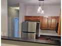 Well-lit kitchen featuring stainless steel appliances, dark countertops, and unique pendant lighting at 2631 Oldgate Dr # 101, Raleigh, NC 27604