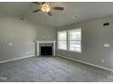 Bright living room featuring a fireplace, neutral carpet, and large windows that provide ample natural light at 279 Constellation Ct, Benson, NC 27504