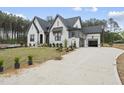 View of a newly constructed home with a white brick exterior, an attached garage, and a concrete driveway at 2809 Theresa Eileen Way, Raleigh, NC 27603