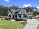 Beautifully landscaped, light colored, single Gathering home, with dark gray accents, driveway and garage at 2809 Theresa Eileen Way, Raleigh, NC 27603