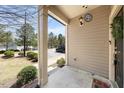 Welcoming front porch area with neutral siding and a charming outdoor light fixture at 30 Holly Berry Ln, Durham, NC 27703