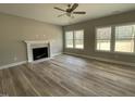 Cozy living room with a fireplace, ceiling fan, and abundant natural light from large windows at 308 Busterfield Ct, Benson, NC 27504