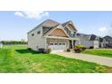 Attractive home with a two-car garage, well-kept lawn, and landscaping on a sunny day at 343 Brinkley Cir, Mebane, NC 27302