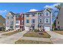 Attractive townhouse exterior featuring colorful siding, attached garage, and a neatly landscaped front yard at 404 Cotton Brook Dr, Fuquay Varina, NC 27526