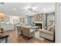 An open living room boasts a fireplace, neutral furniture, wood floors, and lots of natural light at 49 Olivia Crossing Ct # 43, Four Oaks, NC 27524