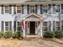 Inviting front porch with a gray-painted entrance and black door, flanked by meticulously maintained shrubs at 5120 Knaresborough Rd, Raleigh, NC 27612