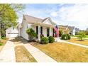 Beautiful white home with a cozy front porch, perfect for enjoying the outdoors with black shutters at 524 Beckwith Ave, Clayton, NC 27527