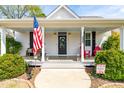 Inviting front porch featuring a comfortable bench, colorful chairs, and a cheery 'Spring' sign at 524 Beckwith Ave, Clayton, NC 27527